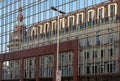 Retro streetlight in front of glass wall with distorted reflection of historic chapel and windows on rooftop