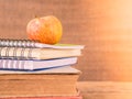 Retro style of apple on stacks of books on wooden table background. Royalty Free Stock Photo