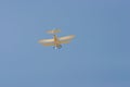 Retro style biplane flying in the air against blue sky Royalty Free Stock Photo