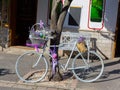 Retro style blue bicycle with lavender flowers as a creative decoration near the shop in the cozy small street Royalty Free Stock Photo