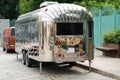 Retro style futuristic silver metal trailer van standing on summer day for fair, festival or event.