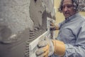 Retro style image of a man placing an ornamental tile in to a glue