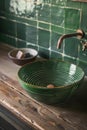 Retro style metal tap and sink in modern bathroom interior with soap bottle and green ceramic tiles wall in the Royalty Free Stock Photo