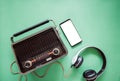 Retro style old boombox radio from 1950s, 1960s and headphones, technology mobile phone blank white space for your text on green Royalty Free Stock Photo