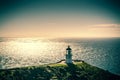 Retro style photo of Cape Reinga Lighthouse with sunshine over sea in the background. Summer evening at the northernmost Royalty Free Stock Photo