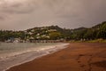 Retro style photo of an empty curve of a sandy beach on a rainy day. Toned image