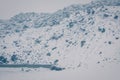 Retro style photo of a rocky slope in heavy snowfall. Blizzard in the mountains. Toned image Royalty Free Stock Photo