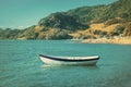 Retro-style photo of a wooden row boat moored in calm waters of the bay Royalty Free Stock Photo