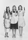 Retro style portrait of beautiful young women, housewives with cooking tools. Black and white image in vintage style