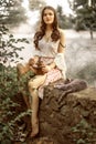 Retro style portrait of pretty young woman holding antique wooden coffee grinder and little gray kitten sleeping on