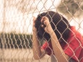 Retro style sad boy behind fence mesh netting. Royalty Free Stock Photo