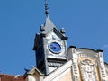 Retro style simple blue tower clock with yellow hands in zink color metal facade