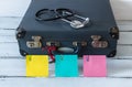 Retro style suitcase with compass and medical stethoscope. Colorful sticky notes with space for an inscription. The concept of saf