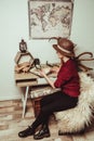 retro style woman in hat with magnifying glass sitting at table
