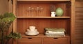 Retro styled cupboard with disheslike plates, tableclothes, vases and glasses