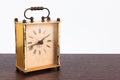 Retro styled image of vintage square table clock on a wooden table.