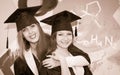 Retro styled portrait of two happy graduating students. Two smiling embracing friends girl in graduation caps and gowns. Royalty Free Stock Photo