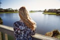 Retro styled woman standing on the wooden bridge and looking at the lake Royalty Free Stock Photo