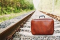 Retro suitcase standing on the railway on a sunny day. Holidays, vacation, travel and trip.