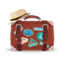 Retro suitcase with travel stickers and fedora hat