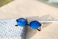 Retro sunglasses model with blue round lenses shoot outside in a summer day closeup . Selective focus
