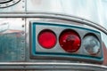 Retro tail lights on silver vehicle with rivets and chrome