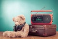 Retro Teddy Bear, old suit case and radio recorder in front mint blue background. Vintage style photo Royalty Free Stock Photo