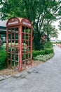 Retro telephone box along  shady walkway Royalty Free Stock Photo