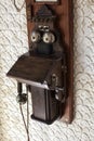 A vintage antique wooden telephone hangs on a wall. Royalty Free Stock Photo