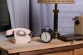 Retro things on table, close upRetro things on table, close up. An old dial phone, a black alarm clock, a table lamp, a book, and Royalty Free Stock Photo