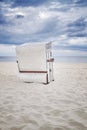 Retro toned hooded wicker chair on beach. Royalty Free Stock Photo