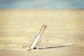 Retro toned message in a bottle on beach, shallow depth of field Royalty Free Stock Photo