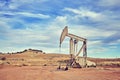 Retro toned picture of an old oil pump. Royalty Free Stock Photo