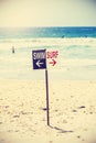 Retro toned swim and surf sign on the beach. Royalty Free Stock Photo