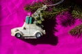 Retro toy car. Christmas tree, gift box on a bright pink backdrop. New Year 2022 Royalty Free Stock Photo