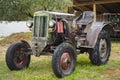 Retro tractor in green summer park.