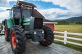 A retro tractor parked next to a barn in a farm.Thailand Royalty Free Stock Photo