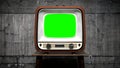 Retro TV receiver with green screen standing on a table, concrete wall in background - 3D 4k animation