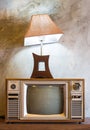 Retro tv with wooden case and lantern in room with vintage wallpaper Royalty Free Stock Photo
