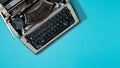 Retro typewriter on blue background with copy space, top view. Literature Blogging Writing Concept