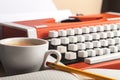 Retro typewriter and coffee cup on background