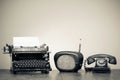 Retro typewriter, old radio, telephone on wooden table. Vintage style sepiaphoto Royalty Free Stock Photo