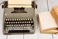 Retro typewriter and old vintage books on white wooden background Royalty Free Stock Photo