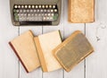 Retro typewriter and old vintage books on white wooden background Royalty Free Stock Photo