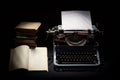 Retro typewriter with stack of book and one opened book