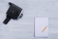 Retro video camera on a light gray desk, with a sheet of checkered paper and a simple pencil, with space for recording Royalty Free Stock Photo