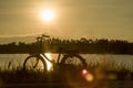 Retro vintage bicycle near the lake at sunset moment. silhouette bicycle at the sunset with grass field.big mountain and sunset Royalty Free Stock Photo