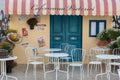 Retro vintage blue wooden door and white chairs, cafeteria cafe setting postcard