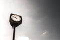 Retro vintage clocktower style street old clock tower in european city scene at daylight under clear sky with desaturated edit. Co Royalty Free Stock Photo