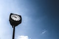 Retro vintage clocktower style street old clock tower in european city scene at daylight under clear sky with desaturated edit. Co Royalty Free Stock Photo